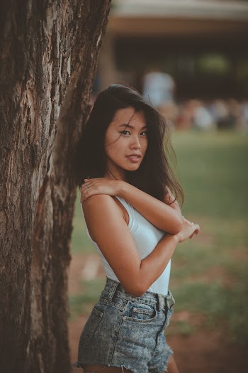 Selective Focus Photography of Woman Standing Beside Tree