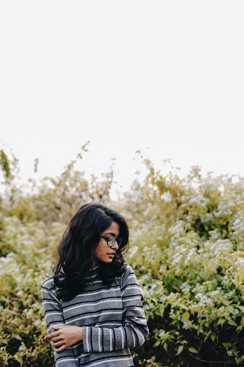 Selective Focus Photography of Woman Standing in Front of Plants