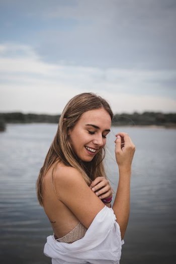 selective focus photography of woman standing near body of water