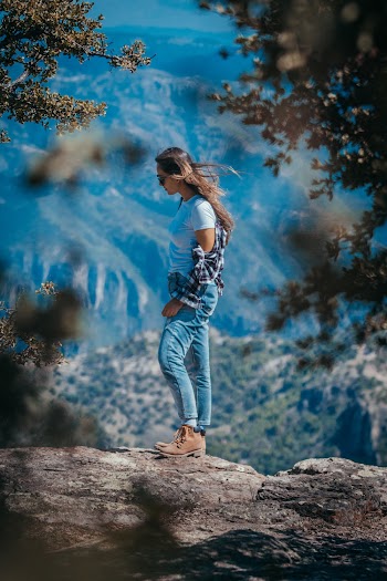 Selective Focus Photography of Woman Standing On Rock