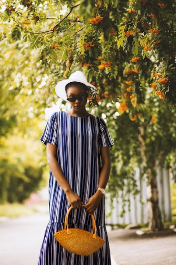 Selective Focus Photography of Woman Standing Under Tall Tree While Holding Brown Tote Bag