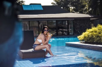 Selective Focus Photography of Woman Wearing Black and White Bikini Sitting Brown Chair