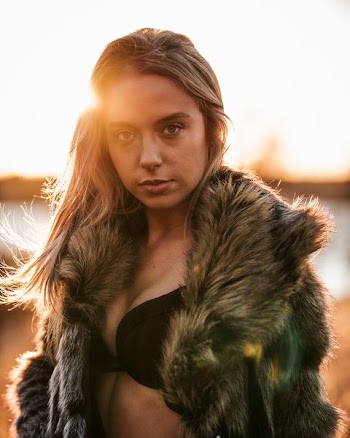 selective focus photography of woman wearing black brassiere and fur coat