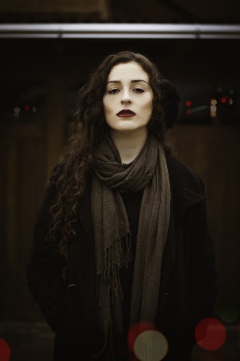 Selective Focus Photography of Woman Wearing Black Coat and Brown Fringe Scarf