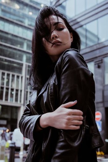 selective focus photography of woman wearing black leather zip-up jacket