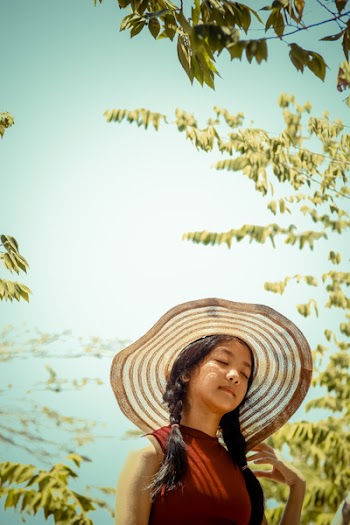 Selective Focus Photography of Woman Wearing Sunhat Near Tree