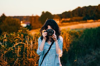 selective focus photography of woman wearing teal and white striped elbow-sleeved blouse
