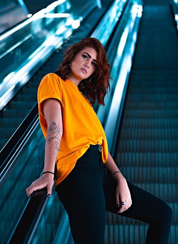 Selective Focus Photography Of Woman Wearing Yellow T-shirt On Escalator
