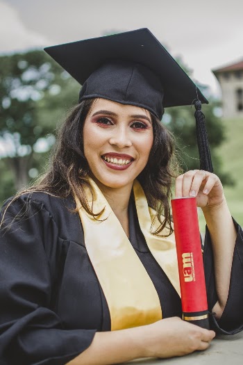 Selective Focus Portrait Photo of Smiling Woman in Black Academic Dress Holding Diploma Posing