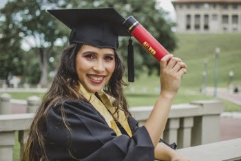 Selective Focus Portrait Photo of Smiling Woman in Black Academic Dress Holding Diploma Posing