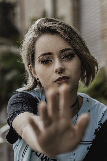 Selective Focus Portrait Photo of Woman Holding Out Her Hand
