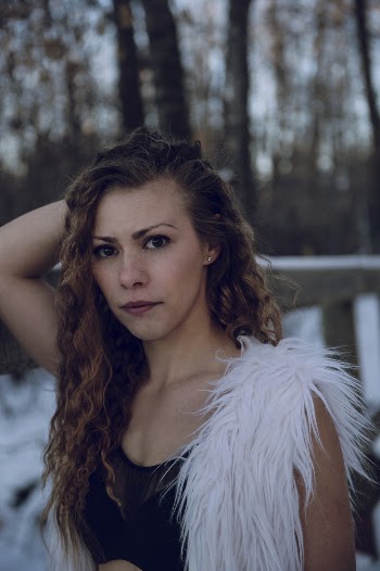 Selective Focus Portrait Photo of Woman in Black Crop Top and White Sleeveless Fur Coat Posing