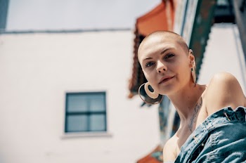 Selective Focus Portrait Photo of Woman in Blue Denim Button-up Jacket Posing