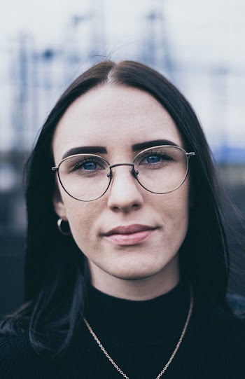 Selective Focus Portrait Photo of Woman in Glasses and Black Top Posing