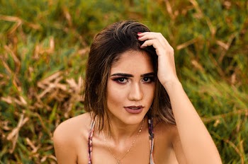 Selective Focus Portrait Photo of Woman Posing While Running Her Fingers through her Hair