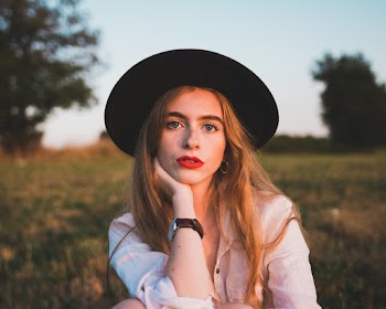 Selective Focus Portrait Photo of Woman Sitting on Grass