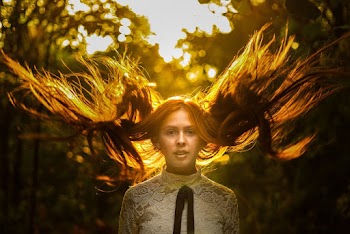Selective Focus Portrait Photo of Woman with Flying Hair in White Lace Top Posing at Golden Hour