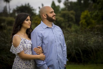 Selective Focus Side View Photo of Couple Standing Near Green-leafed Plants Looking Away