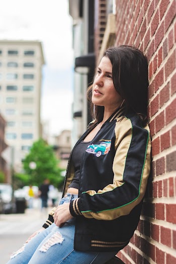 Selective Focus Side View Photo of Woman Leaning on Brown Brick Wall Looking Away