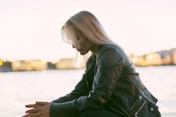 Selective Photography of Woman Sitting Near Body of Water