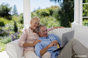 Senior couple online shopping with credit card and laptop