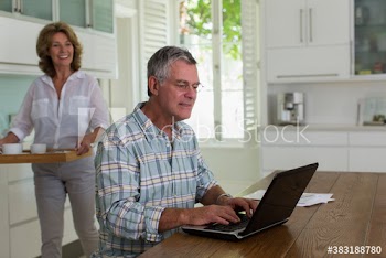 Senior couple using laptop in kitchen