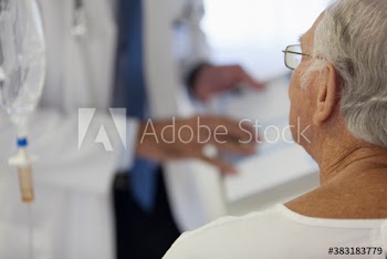 Senior male patient listening to doctor in hospital