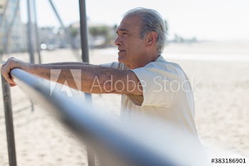 Senior man exercising on sunny beach