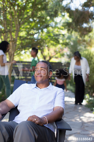 Senior man relaxing on patio with family
