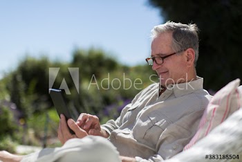 Senior man using digital tablet in sunny garden