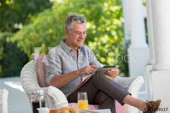 Senior man using digital tablet on patio