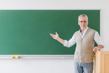 Senior professor pointing at blackboard Free Photo