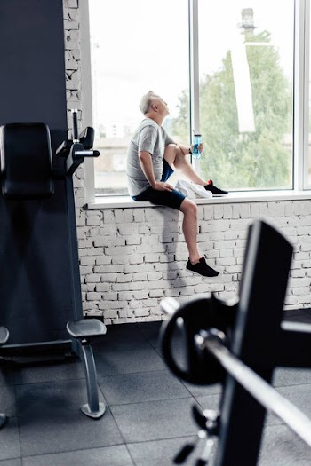 Senior sportsman resting in gym