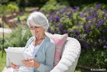 Senior woman using digital tablet in sunny garden