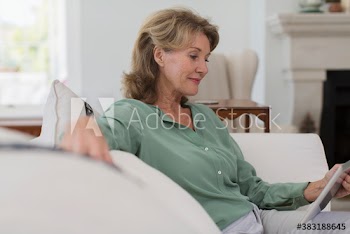 Senior woman using digital tablet on sofa