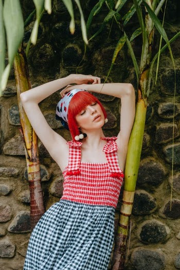 Sensual woman standing with arms raised in tropical garden · Free Stock Photo