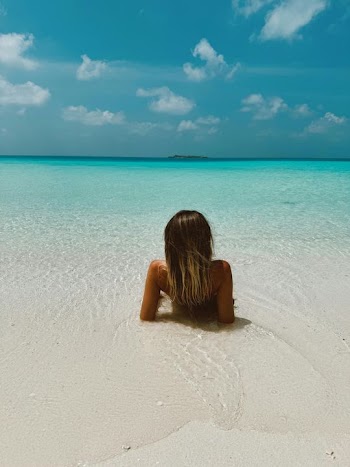 Serene Beach Escape: Woman Relaxing in Turquoise Waters