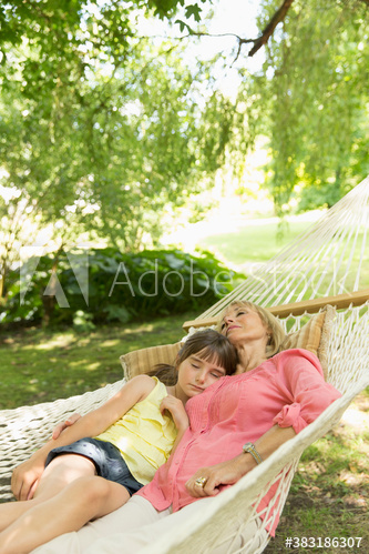 Serene grandmother and granddaughter relaxing in hammock
