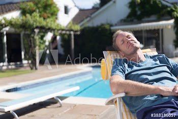 Serene man relaxing at sunny poolside