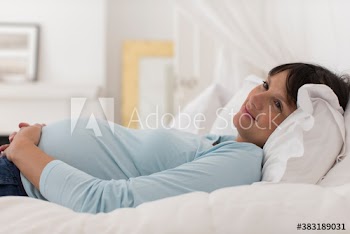 Serene pregnant woman sleeping on bed