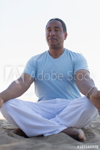 Serene senior man meditating on beach