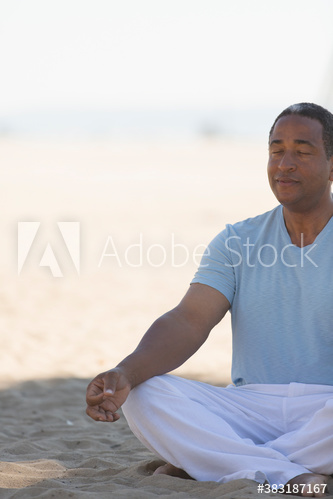 Serene senior man meditating on beach