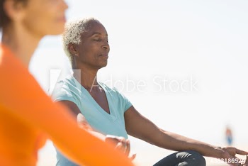 Serene senior woman meditating in sunshine