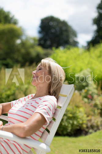 Serene senior woman relaxing in sunny garden