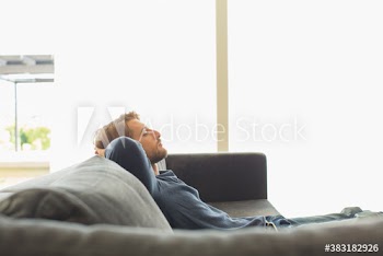 Serene young man relaxing on sofa