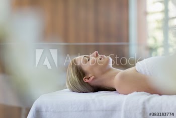 Serene young woman laying on spa massage table