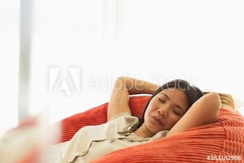 Serene young woman napping in beanbag chair