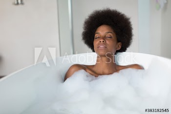 Serene young woman relaxing in bubble bath