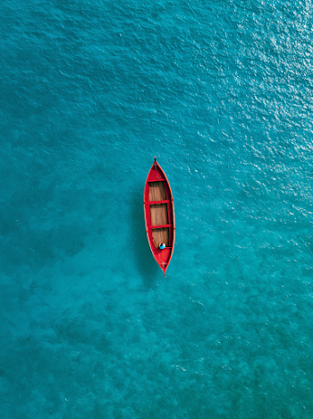 Serenity on Crystal Waters with a Red Boat
