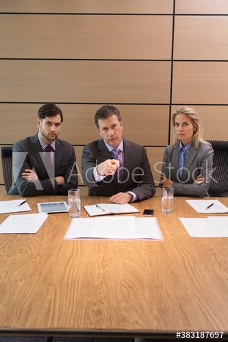 Serious businessman pointing in conference room meeting